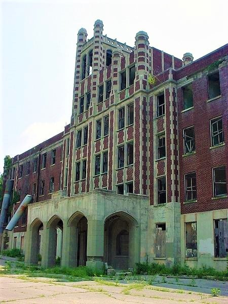 Gothic five-story facade of Waverly Hills Sanatorium on a Louisville Kentucky ridgeline at dusk