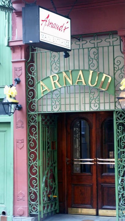 Close view of Arnaud's wrought-iron entrance gate and door, with the 'ARNAUD' name worked into the ironwork over the doorway.