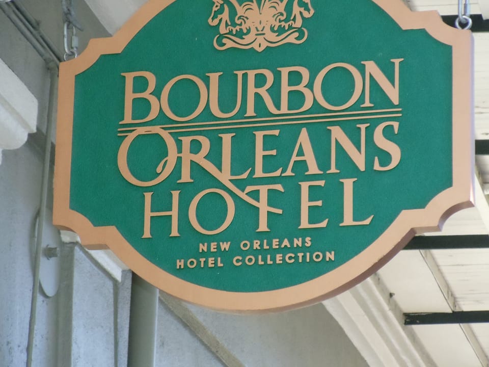 Close-up of the Bourbon Orleans Hotel's green and gilt entrance sign, reading 'Bourbon Orleans Hotel, New Orleans Hotel Collection,' 2013.