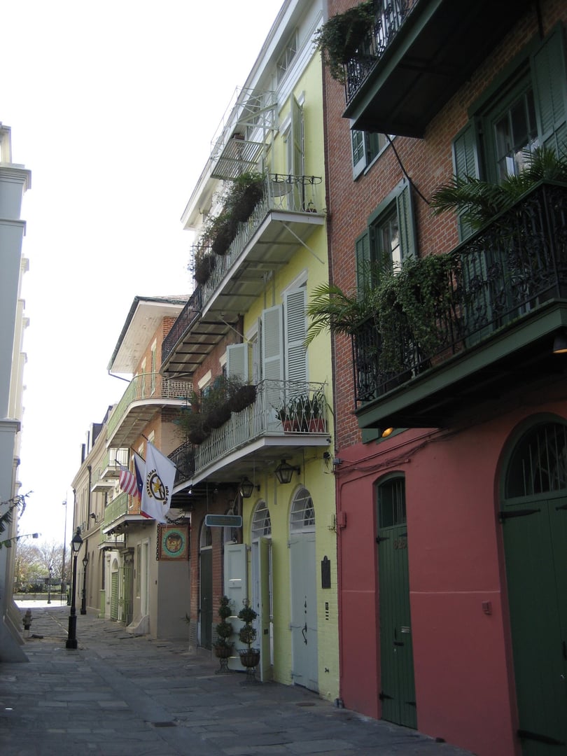 Yellow stucco facade of Faulkner House Books at 624 Pirate's Alley, the former residence of William Faulkner adjacent to St. Louis Cathedral in the New Orleans French Quarter