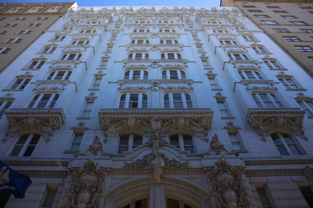 Upward-angle view of the Hotel Monteleone's ornate high-rise facade and balconies, New Orleans.