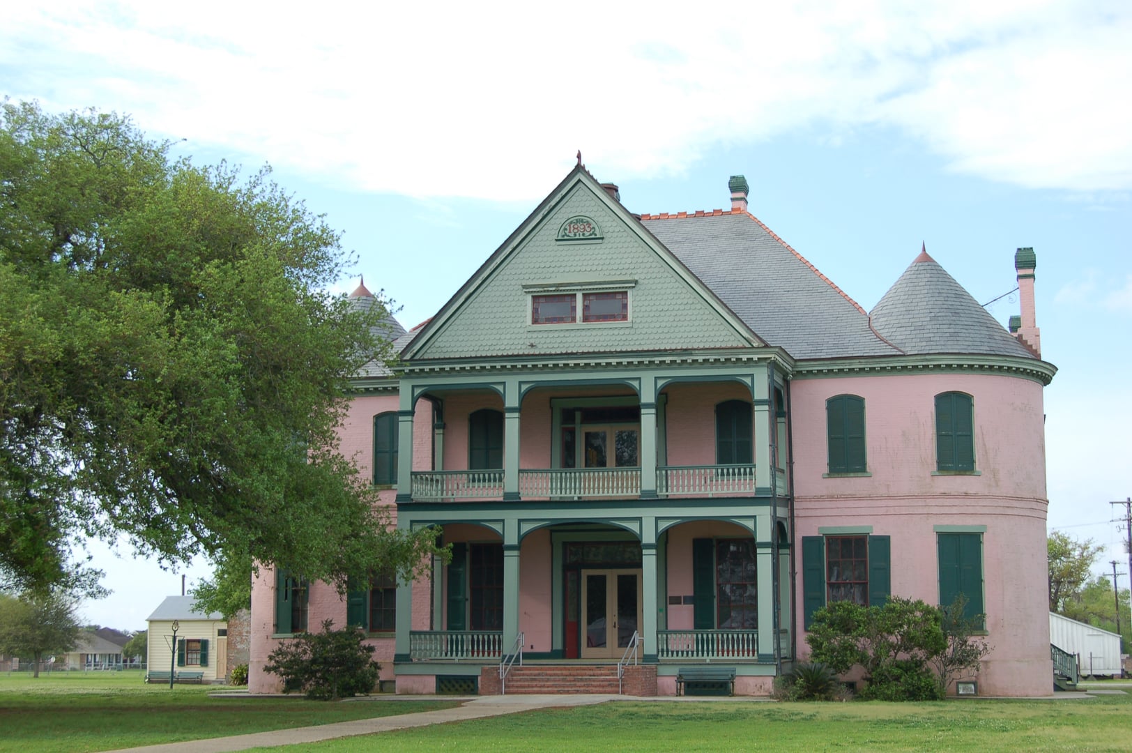 The two-story 1858 Southdown Plantation House with wraparound porches and pink Victorian trim in Houma, Terrebonne Parish, Louisiana.