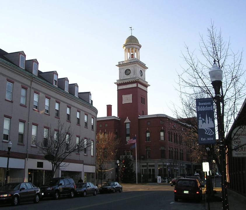 City Hall's red-brick clock tower with gilded cupola and the corner block that houses City Theater, seen from Main Street, Biddeford, Maine, 2005.