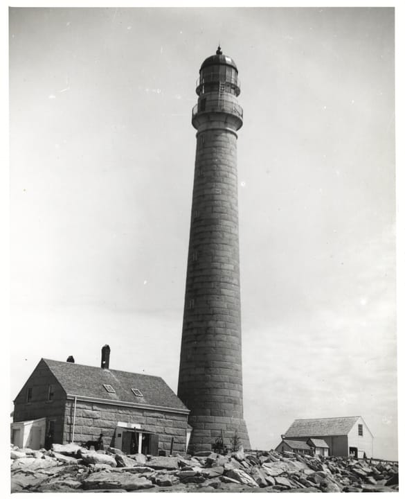 Historic black-and-white photo of the granite tower and the original keeper's dwelling at Boon Island Light Station