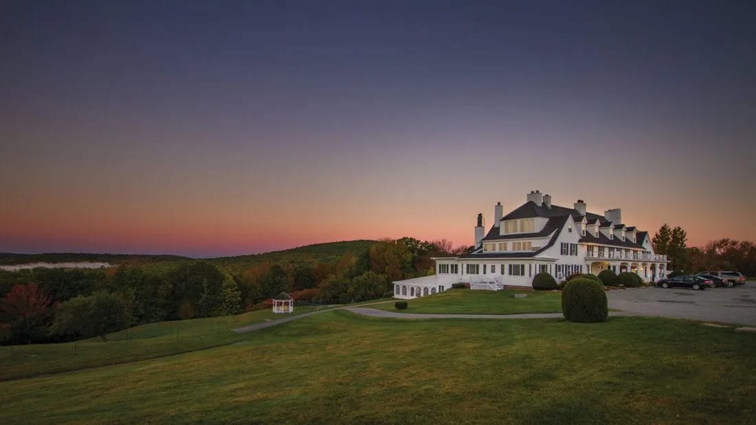 Federal-style white clapboard Lucerne Inn overlooking Phillips Lake in Dedham, Maine