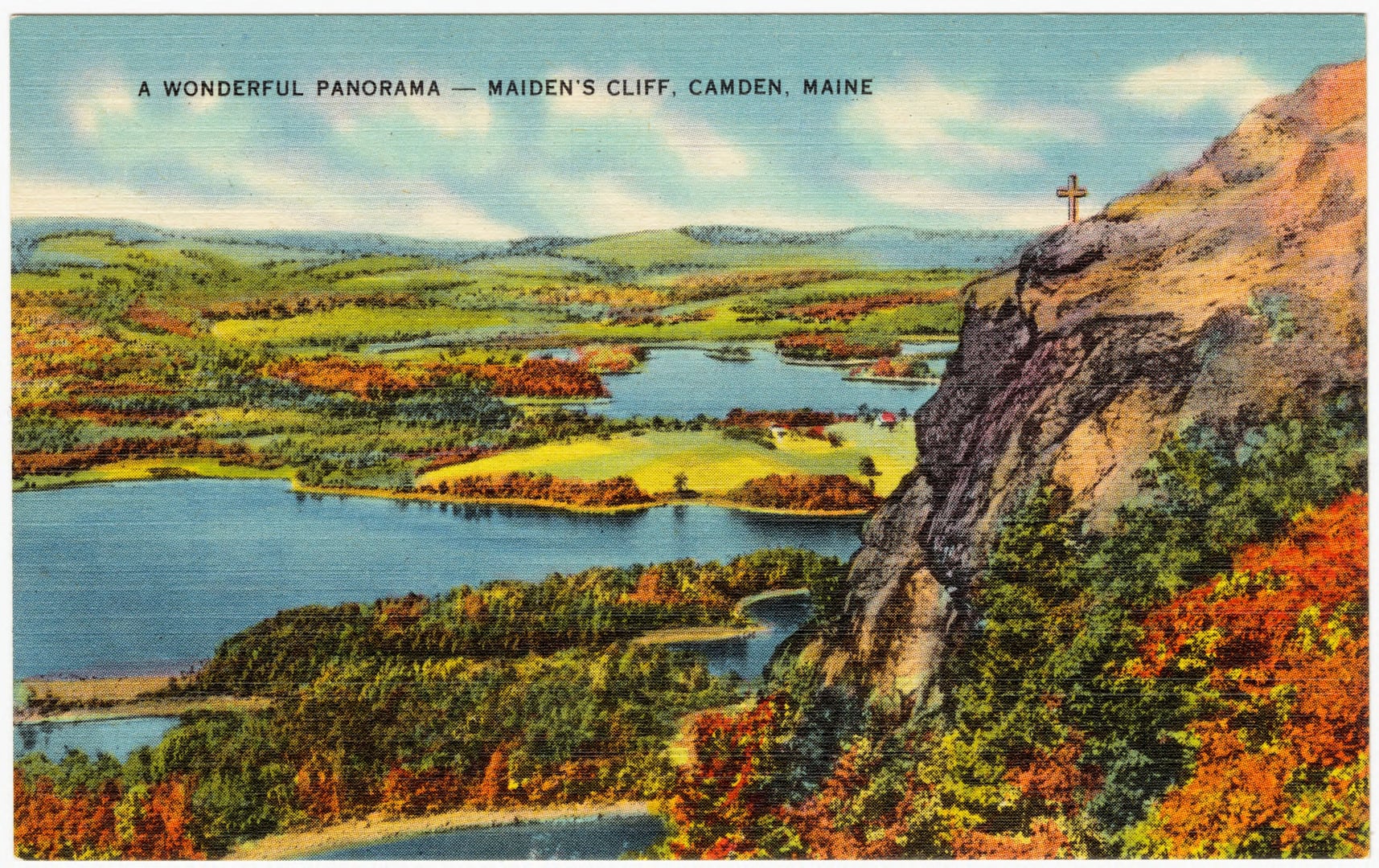 The white memorial cross at the edge of Maiden's Cliff above Megunticook Lake in Camden, Maine