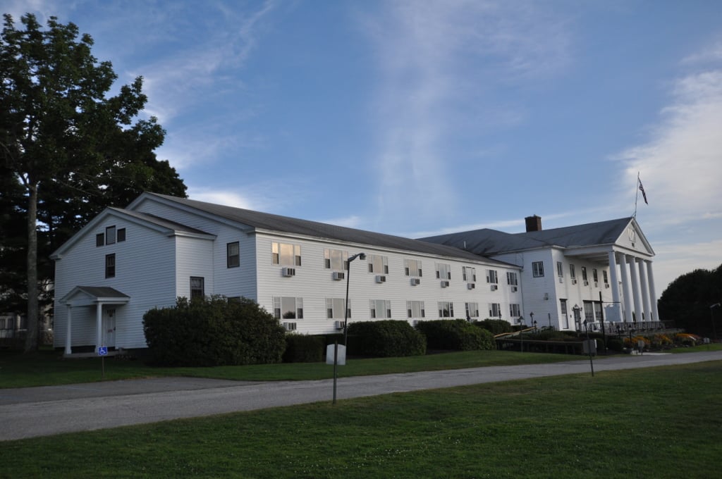 Historic Maine resort buildings on the Poland Spring property surrounded by landscaped grounds and pine forest