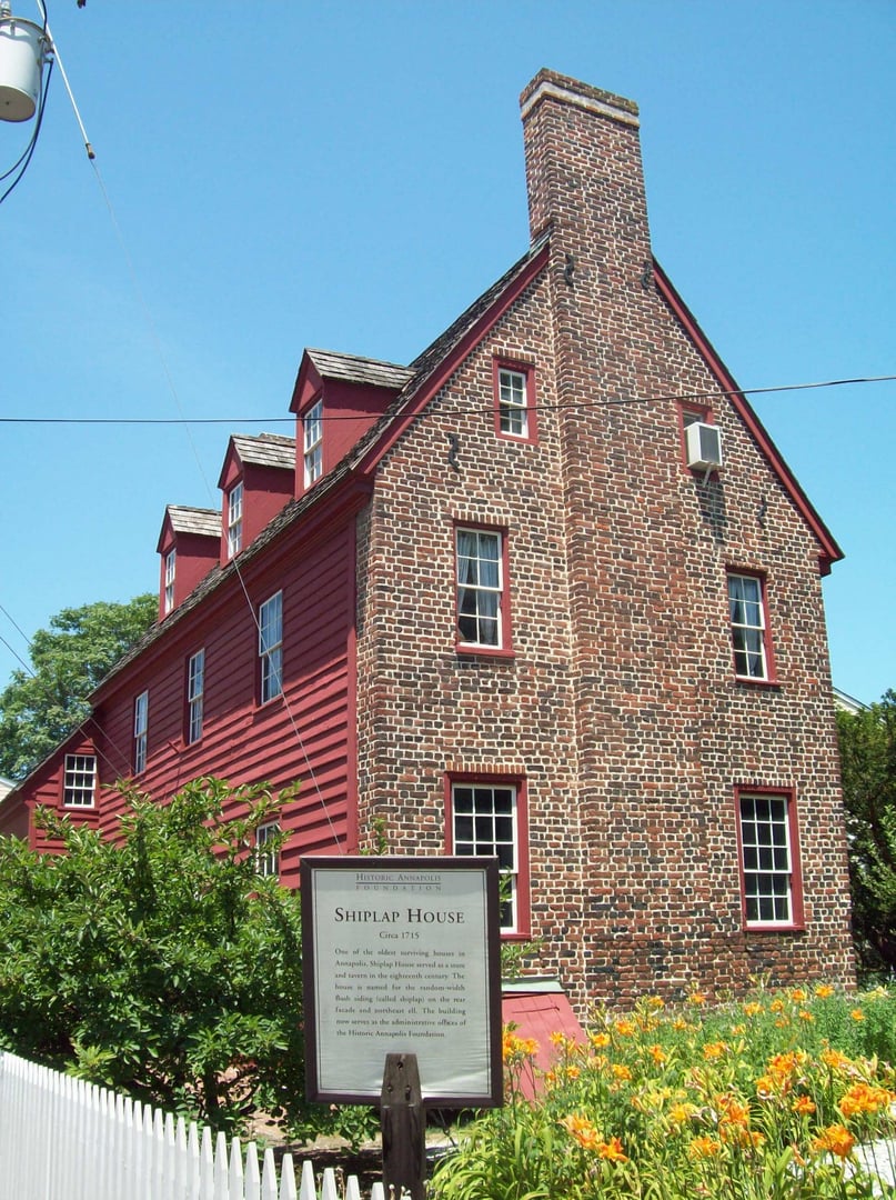The early-18th-century shiplap-sided yellow facade of the Shiplap House on Pinkney Street in Annapolis