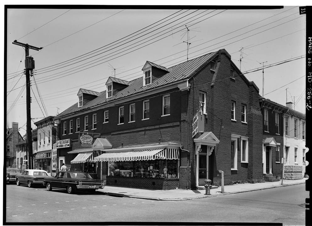Middleton Tavern's building, recorded by the Historic American Buildings Survey as the Old Inn (Marx House), seen from the corner of Dock and Randall Streets in Annapolis with its three dormers and a shop awning, 1964.