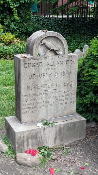 The marker at Poe's original 1849 burial plot, elsewhere in the churchyard from his 1875 memorial monument, inscribed with both dates