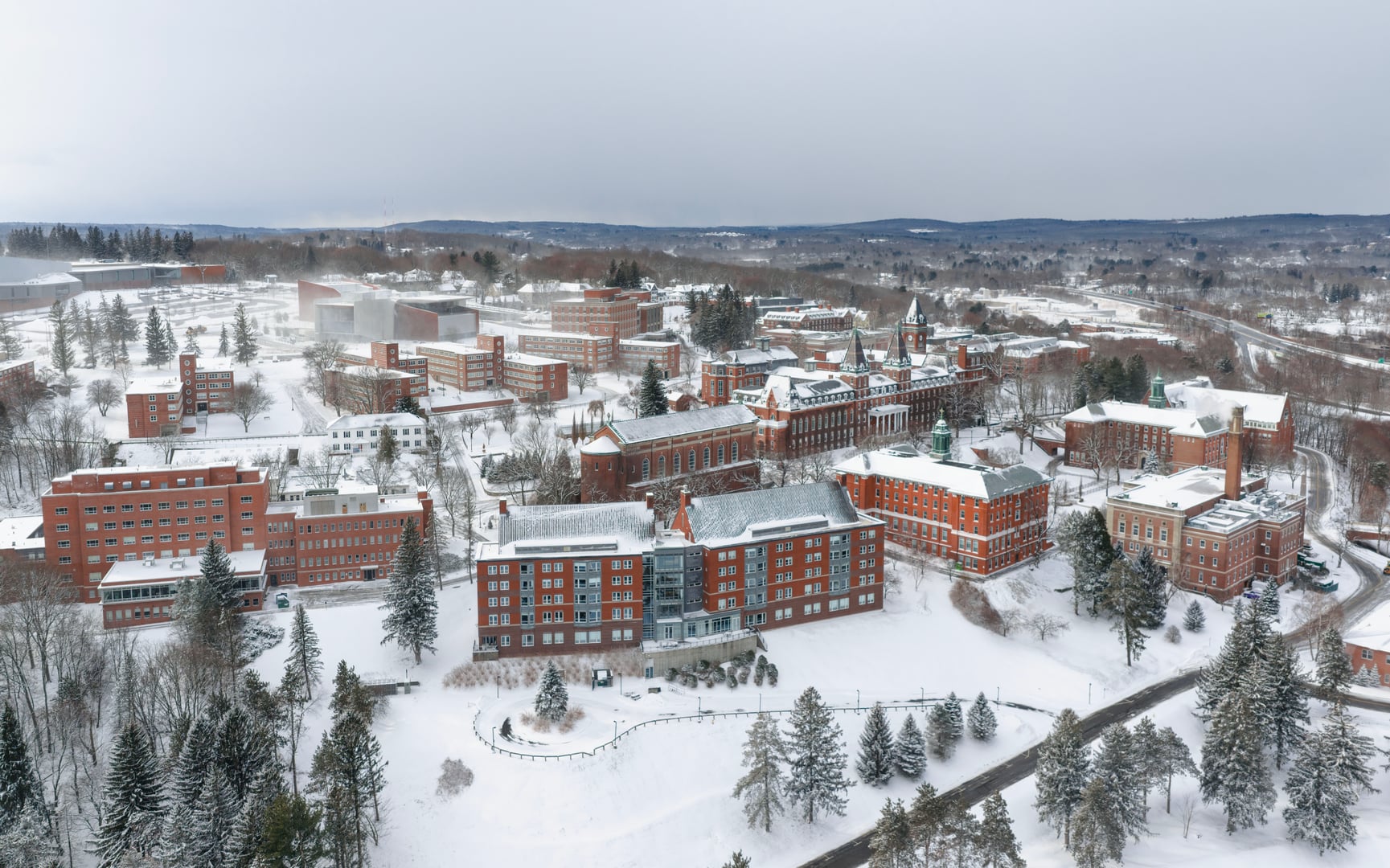 Aerial view of the College of the Holy Cross campus on Mount Saint James in winter, showing historic Fenwick and O'Kane Halls, Worcester, Massachusetts