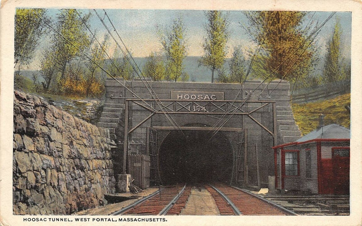 The west portal of the Hoosac Tunnel with its masonry face lettered 'Hoosac' and a small signal cabin beside the tracks, on a white-border postcard of about 1915-30.