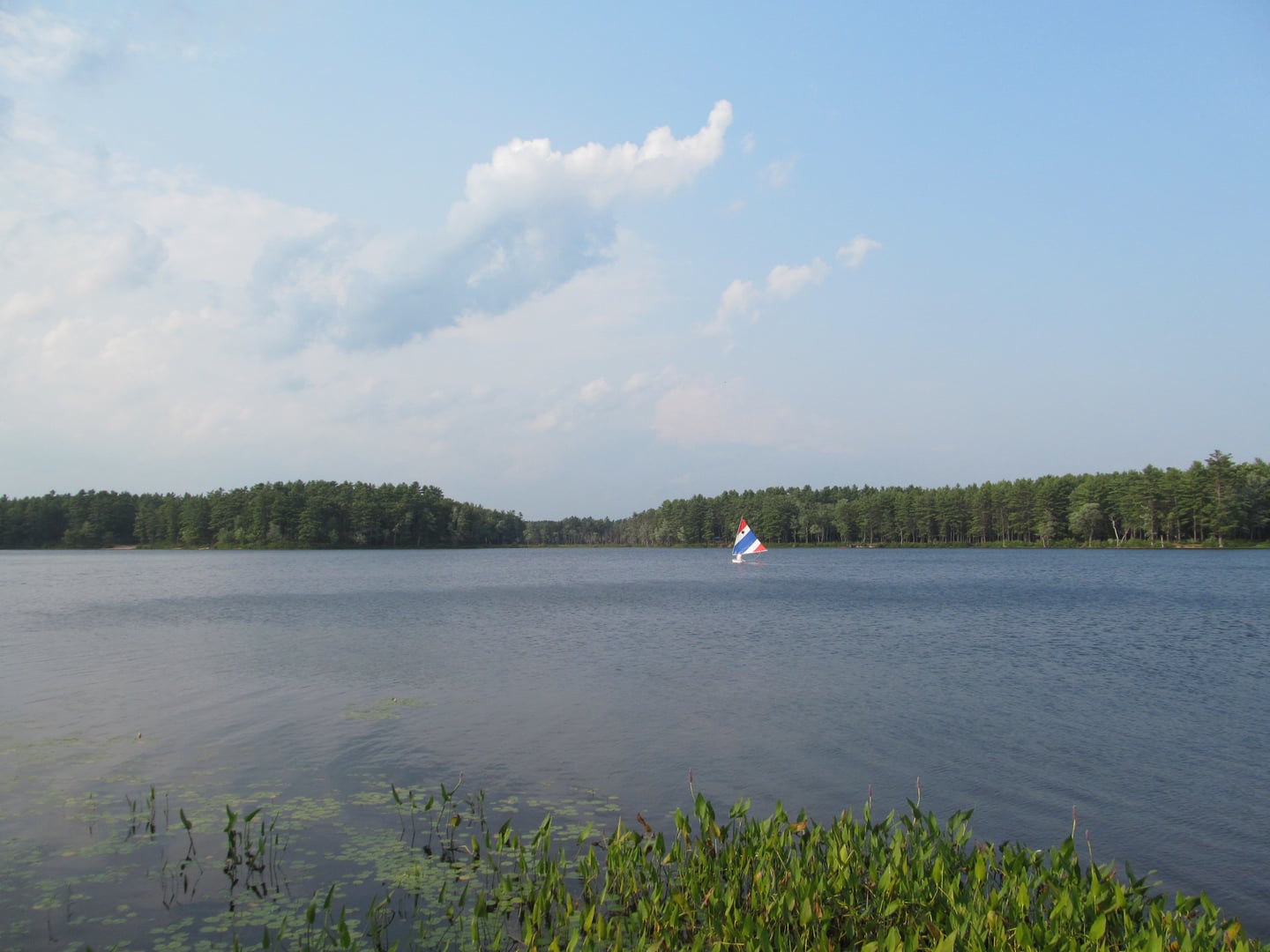 Calm waters and wooded shoreline of Lake Dennison in the Lake Dennison Recreation Area in Winchendon, Massachusetts