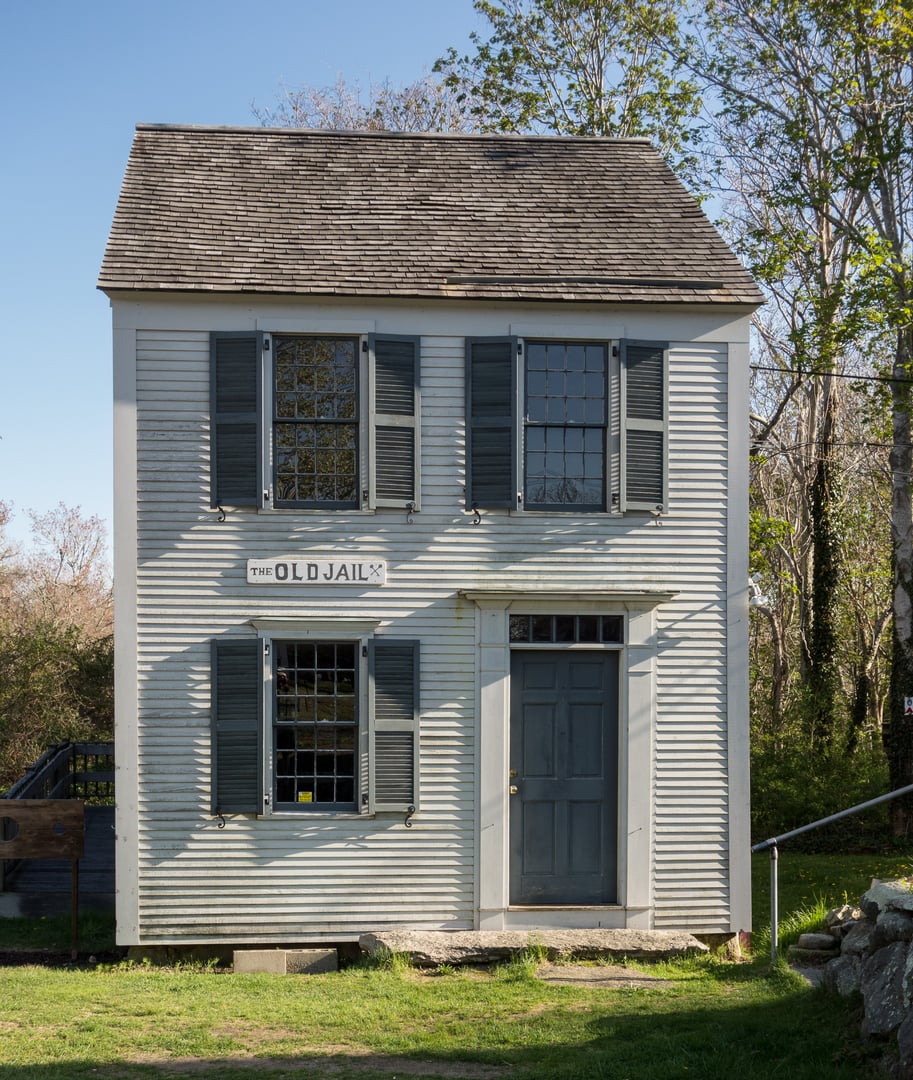 The 1690 Old Gaol, a small weathered wooden jail in Barnstable Village on the grounds of the U.S. Coast Guard Heritage Museum