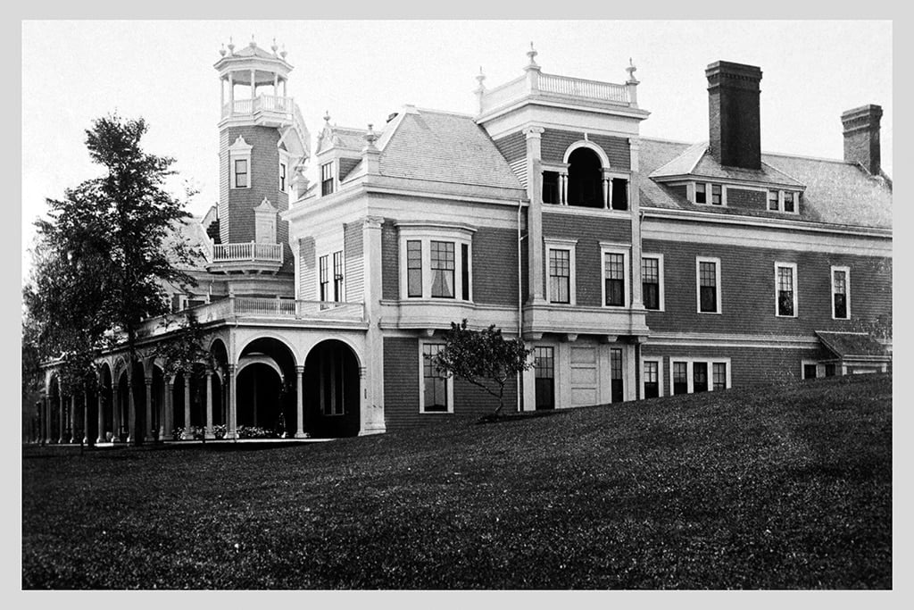Three-story Colonial Revival mansion with wraparound porch overlooking Cape Cod Bay