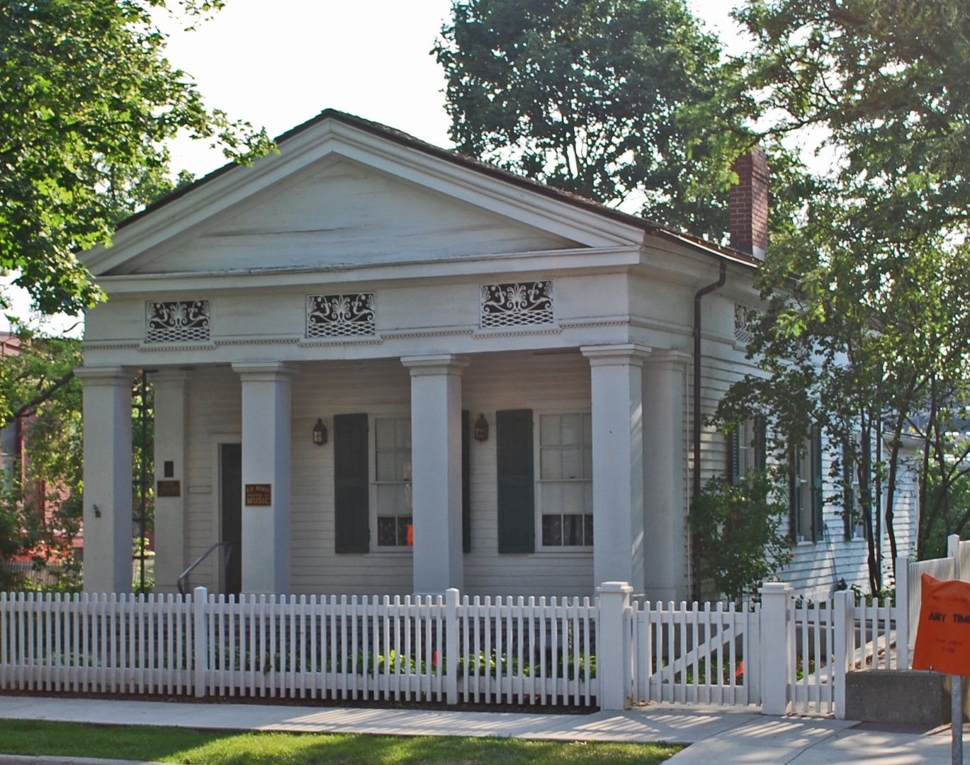 Exterior of the Kempf House Museum, an 1853 Greek Revival temple-form home with four Doric columns at 312 S Division Street, Ann Arbor, Michigan