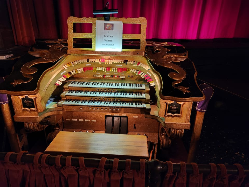 The Redford Theatre's Barton 3-manual theatre organ console, raised in front of the stage curtain