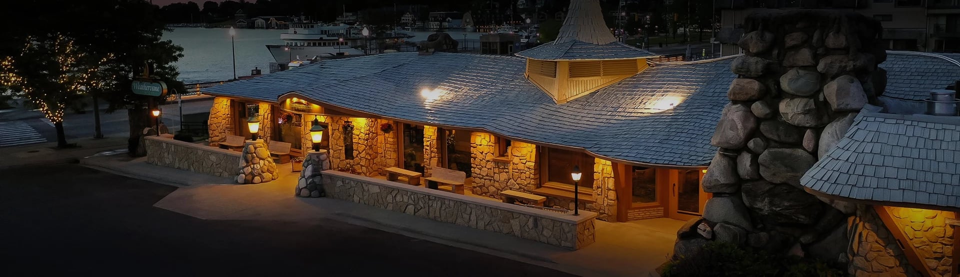 Exterior of Stafford's Weathervane Restaurant at 106 Pine River Lane in Charlevoix, Michigan, an Earl Young-designed former grist mill with curved stonework architecture