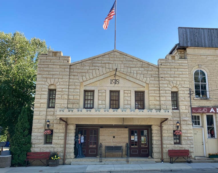 Exterior facade of the Mantorville Opera House, a 1918 limestone block theater on Fifth Street in Mantorville, Minnesota, with the date 1918 carved above the entrance