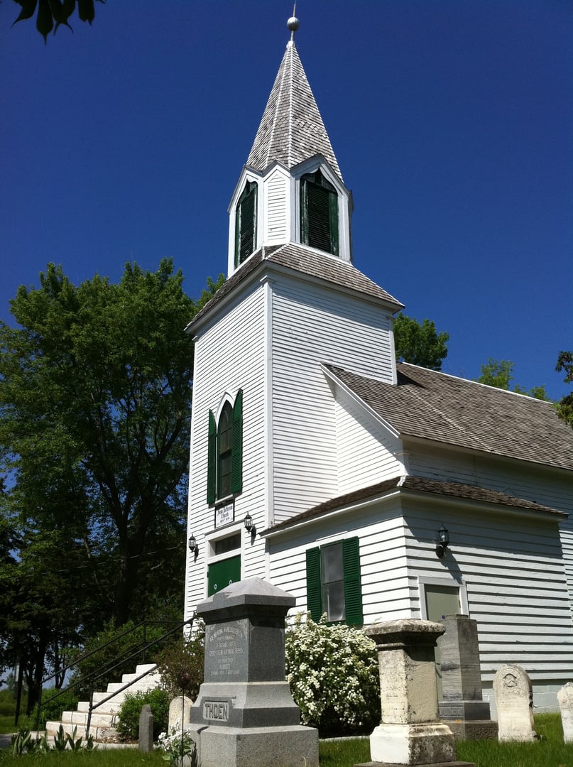 Historic Ness Lutheran Church, a white clapboard building from 1874 with the cemetery in the foreground