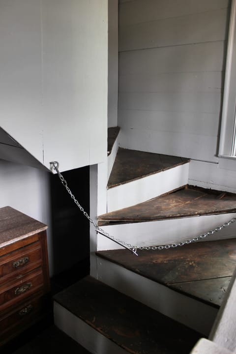A narrow interior staircase inside King's Tavern, roped off with a chain at the base.
