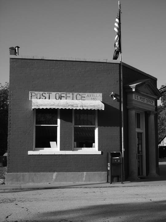 Detail of the 1915 Bank of Avilla building's carved stone lintel reading 'POST OFFICE / AVILLA MO', 2024.