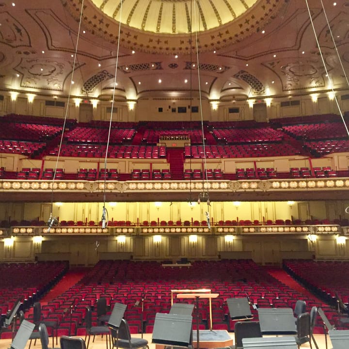 The auditorium of Powell Symphony Hall seen from the stage, with the domed ceiling, two balcony tiers and red seating, photographed in 2019 before the 2023-25 renovation.