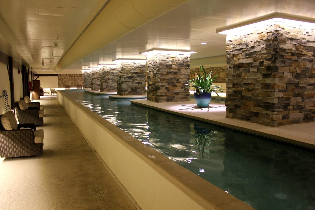 The Elms Hotel's indoor lap pool beneath stacked-stone columns, part of the hotel's spa, Excelsior Springs, Missouri.