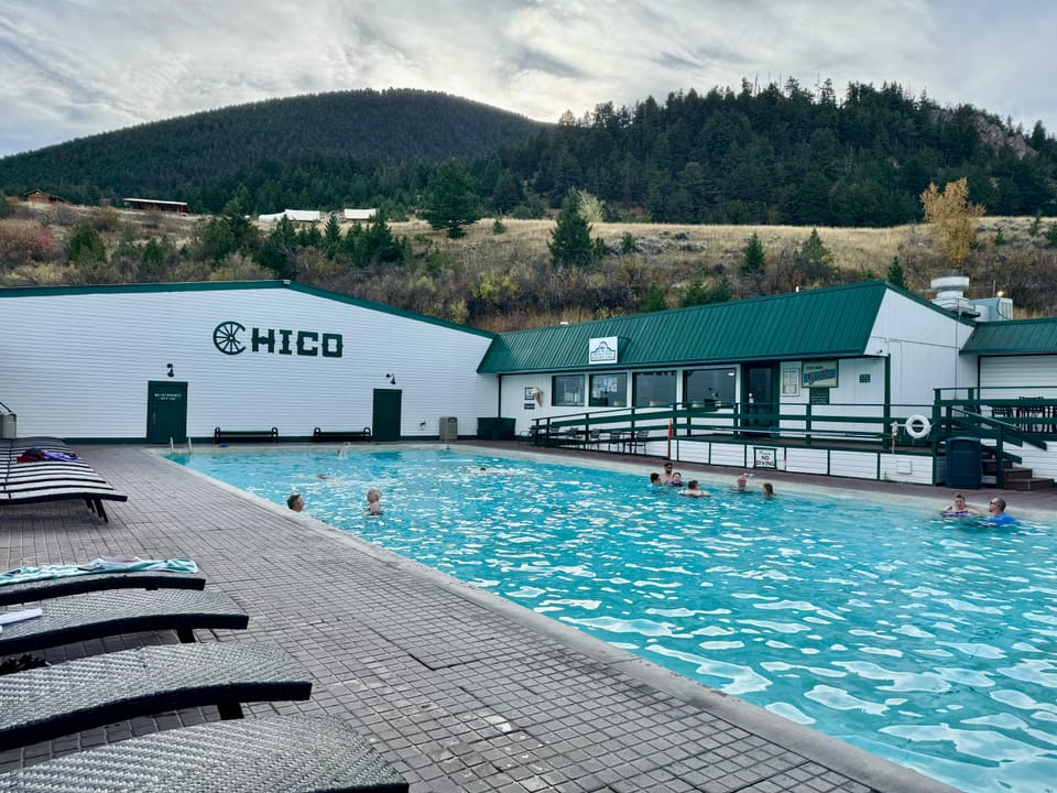 The outdoor mineral hot-spring pool at Chico Hot Springs, with the 'CHICO' pool house and the Paradise Valley hills behind.