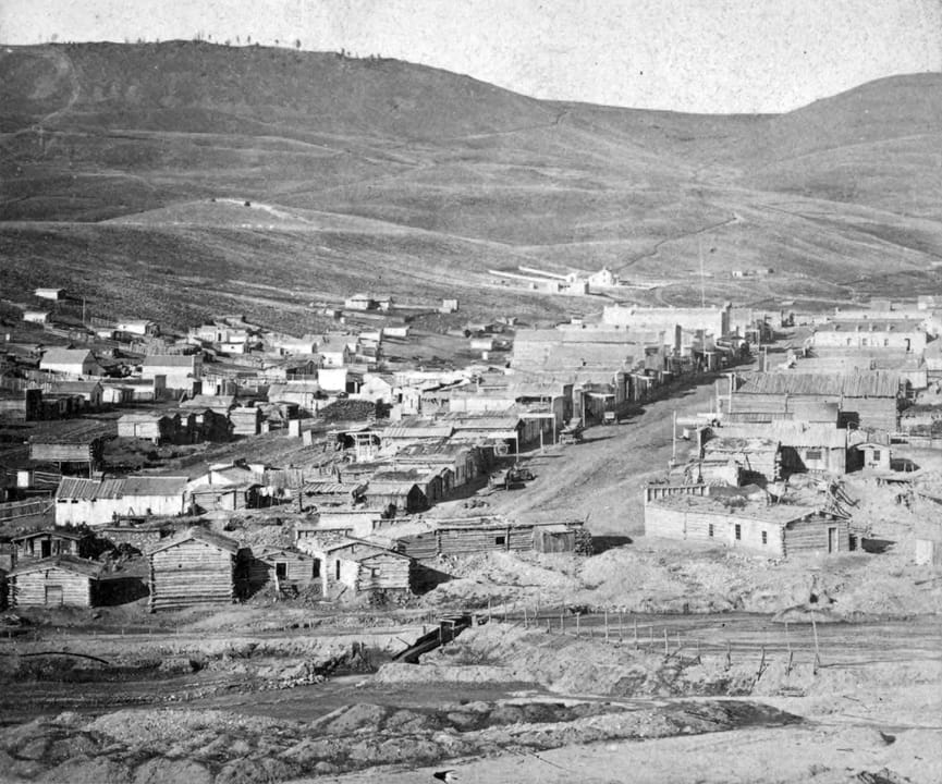 An overview of Virginia City nestled in its hillside setting, photographed from Alder Gulch in the late 1890s by pioneer photographer Charles Roscoe Savage.