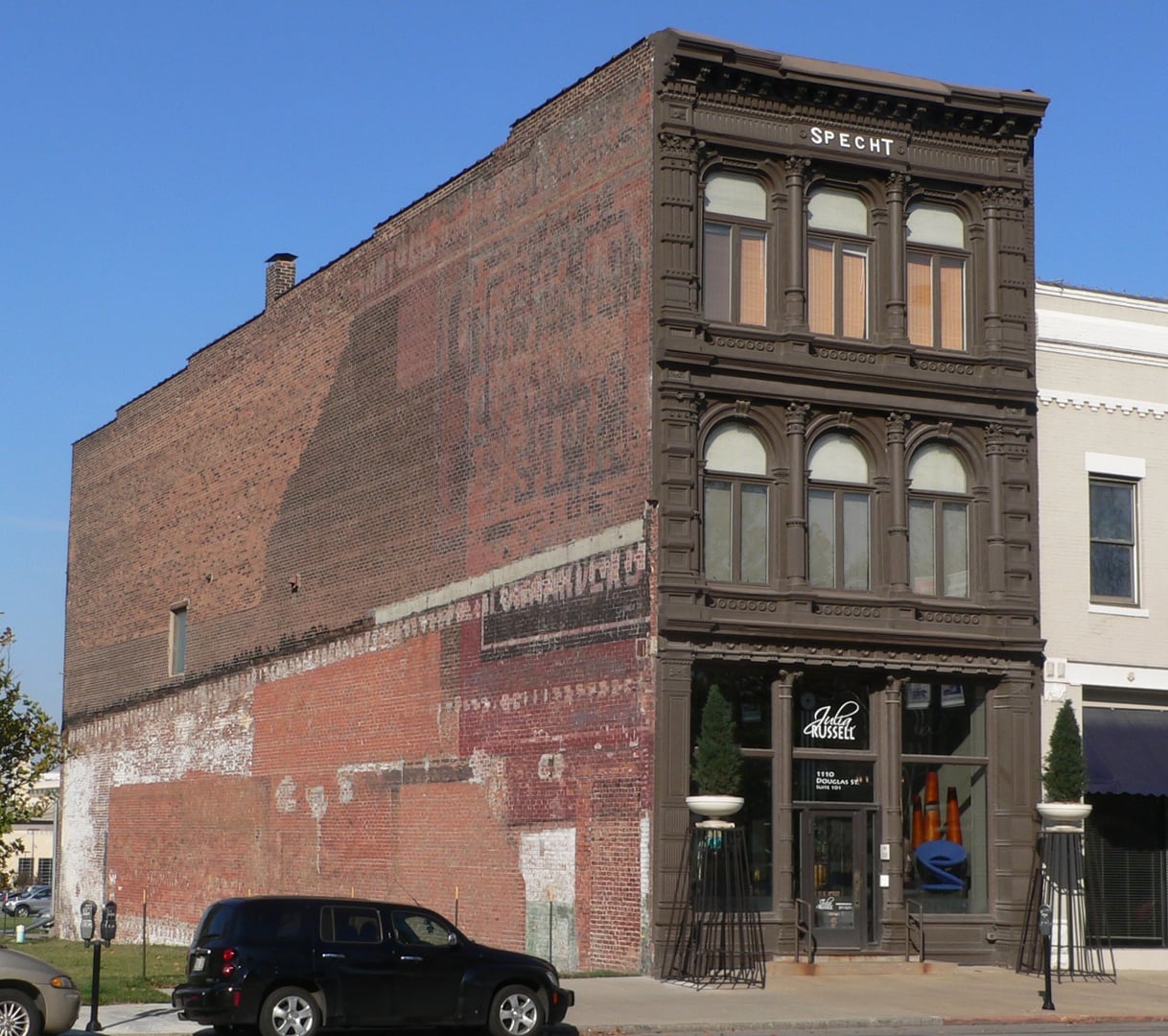 The Christian Specht Building, 1110 Douglas Street, Omaha -- the Museum of Shadows's building since June 2020 -- full three-story Italianate cast-iron-front facade, three-quarter view from the southwest.