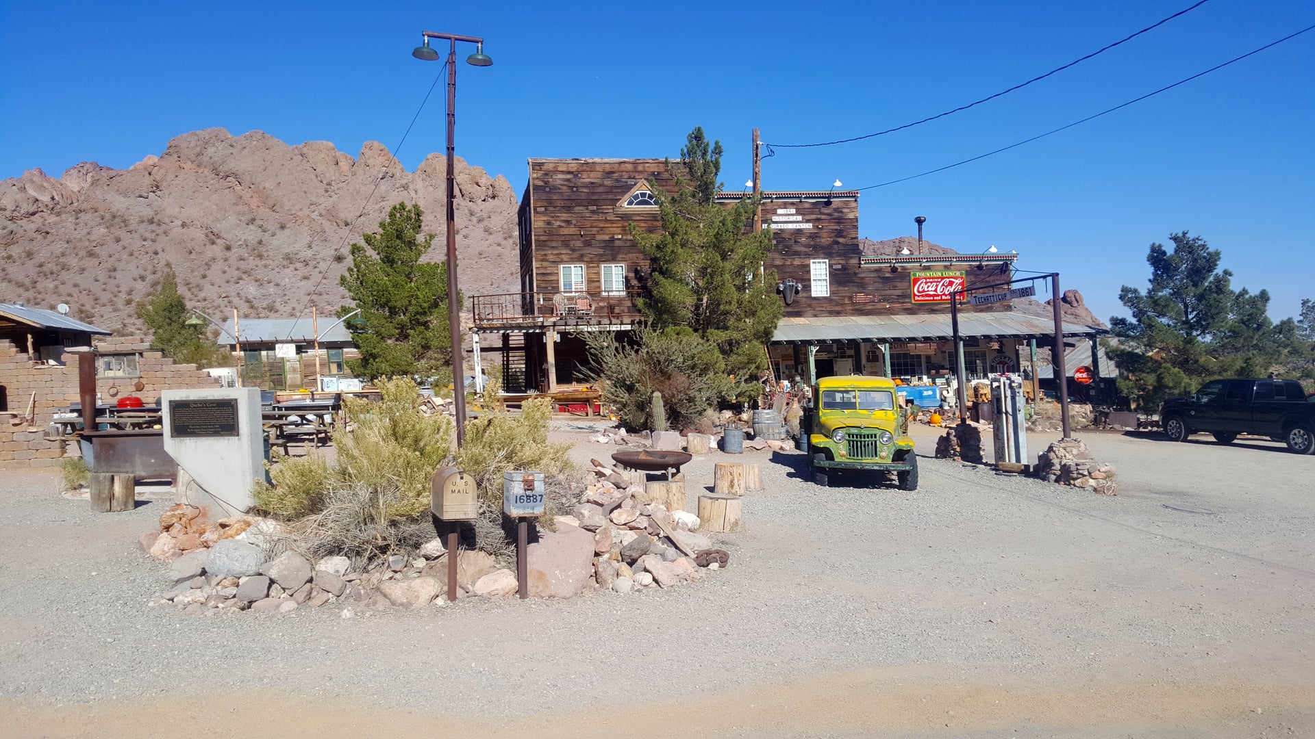 Weathered wooden mining shacks and rusted vehicles populate the desert ghost town of Nelson, Nevada in the Eldorado Mountains