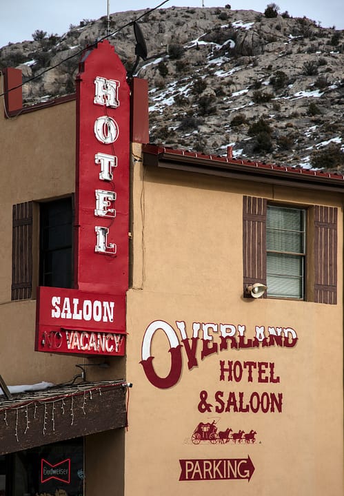 The Overland Hotel & Saloon on Main Street in Pioche, Nevada, its parapet lettered OVERLAND HOTEL & SALOON above the boardwalk porch, July 2023.