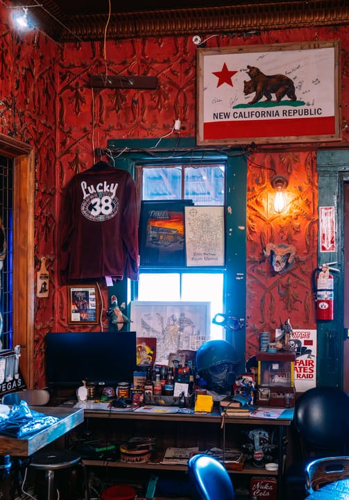 Interior corner of the Pioneer Saloon decorated with an Old West / New California Republic theme (red wallpaper, desk, memorabilia), Goodsprings, Nevada.