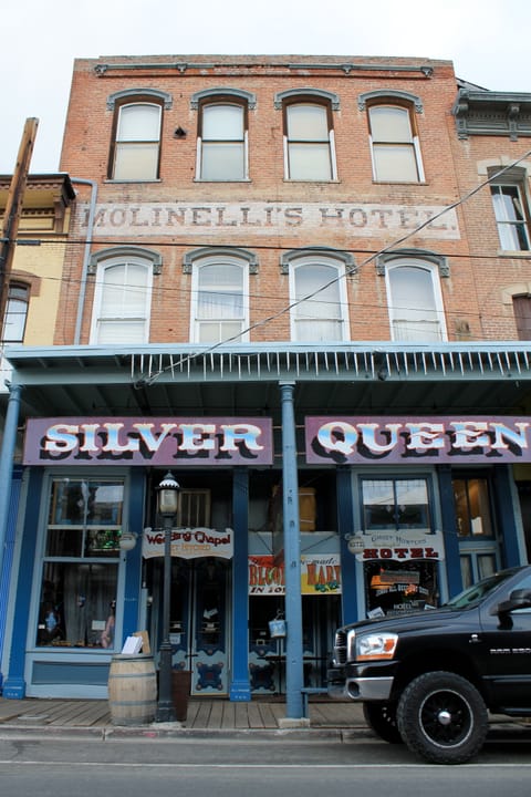 Wider daylight view of the Silver Queen Hotel's C Street facade, Virginia City, Nevada, with the adjoining Molinelli's Hotel building above.