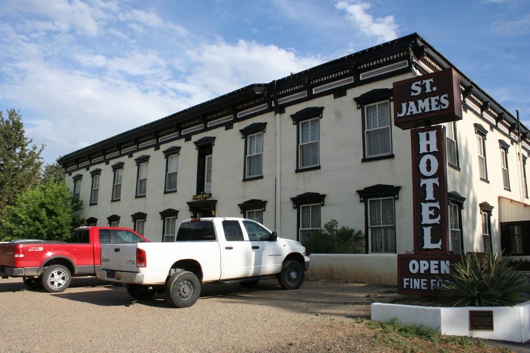 National Park Service Santa Fe National Historic Trail walking-tour photo of the St. James Hotel's front entrance, with its period sign reading 'ST. JAMES HOTEL ... OPEN ... FINE FOOD'.