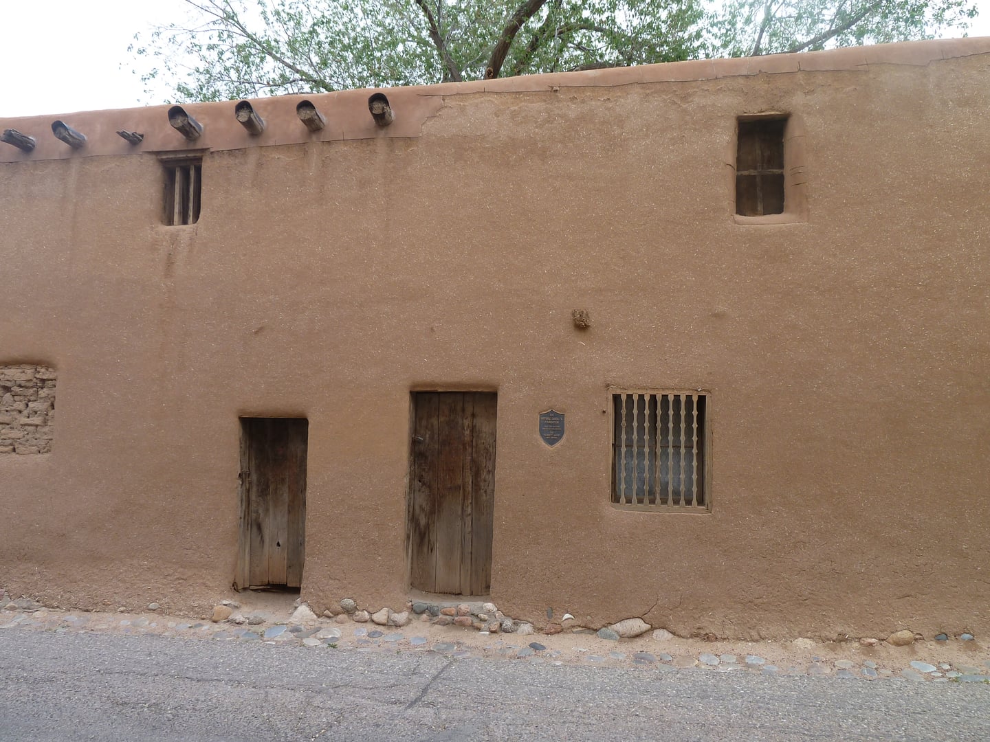 Low adobe walls of the Oldest House on De Vargas Street in Santa Fe, New Mexico