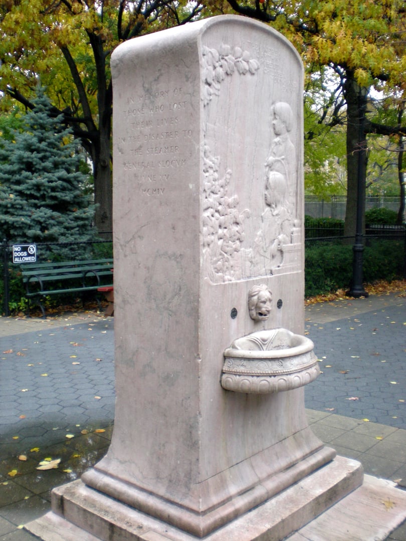 The 1906 General Slocum memorial fountain in Tompkins Square Park, East Village, Manhattan—a pink Tennessee marble stele with two children in relief.