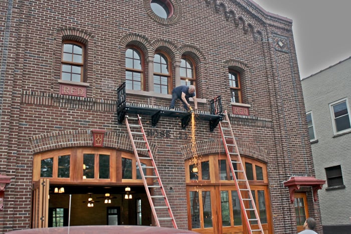 Exterior facade of the 1916 Hose Company No. 22 firehouse on Stutson Street Rochester New York during restoration showing RFD brickwork and arched windows