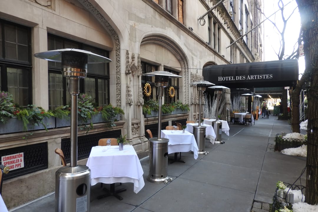 Looking east at restaurant with tablecloth tables on the sidewalk