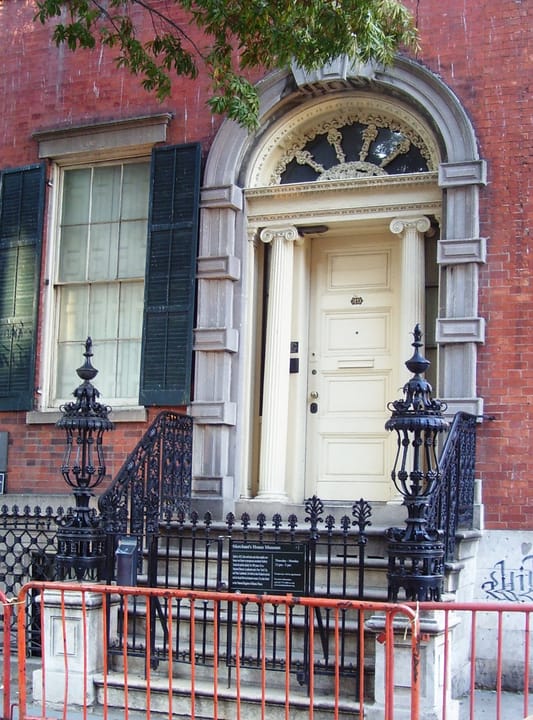 Close-up of the Merchant's House Museum's Greek Revival marble doorway, fanlight and cast-iron stoop railing at 29 East 4th Street.