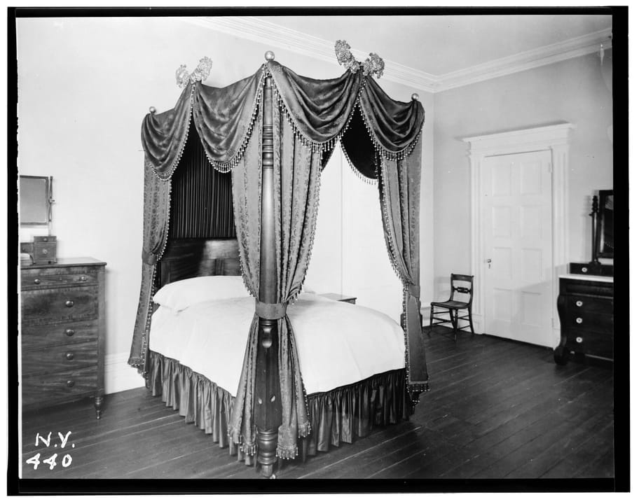 Second-floor back bedroom of the Merchant's House Museum (Seabury Tredwell House), showing the original draped four-poster bed and period furnishings; photographed for the Historic American Buildings Survey, May 25, 1936.