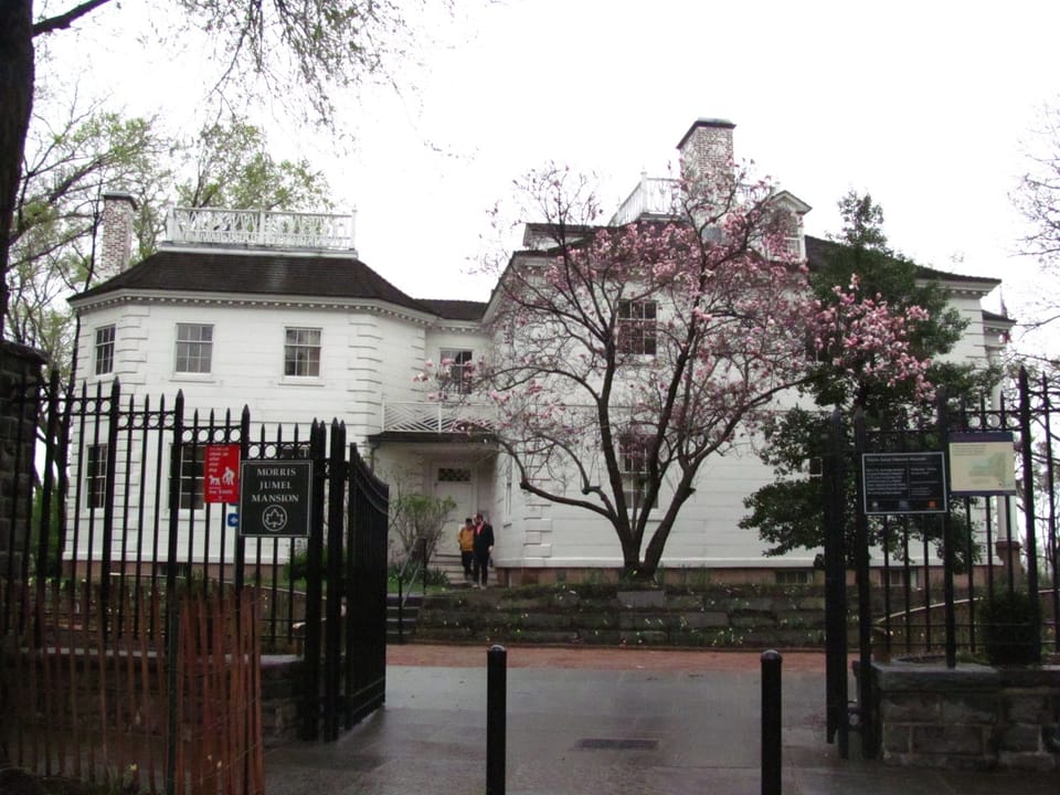 Morris-Jumel Mansion seen through its entrance gate, with the octagonal wing and museum sign visible