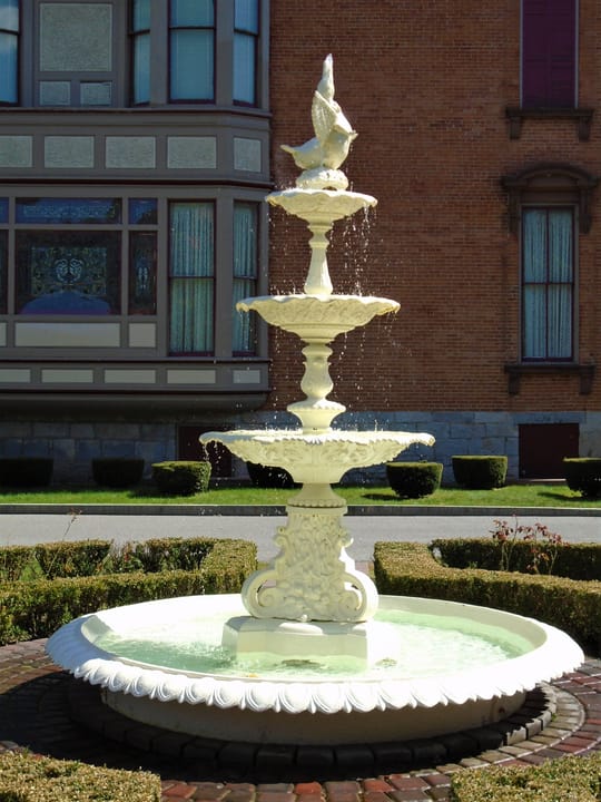 An ornamental tiered fountain on the Canfield Casino's grounds, with the main building behind.