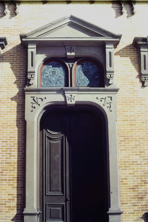 A carved stone doorway with a stained-glass transom on the Canfield Casino's facade.