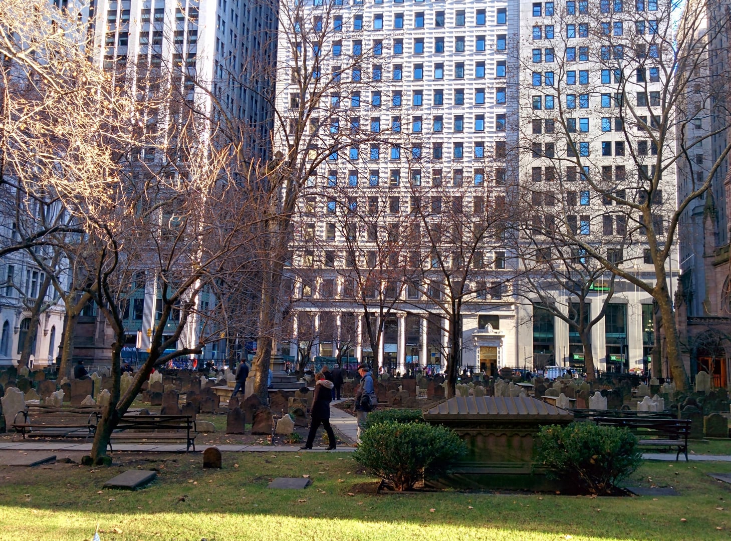 Gothic Revival spire of Trinity Church at 75 Broadway with the head of Wall Street and the churchyard tombs in the foreground.