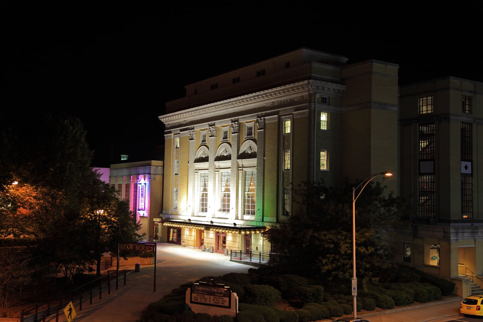 Nighttime exterior of the 1926 Carolina Theatre of Durham, North Carolina, illuminated marquee and entrance.