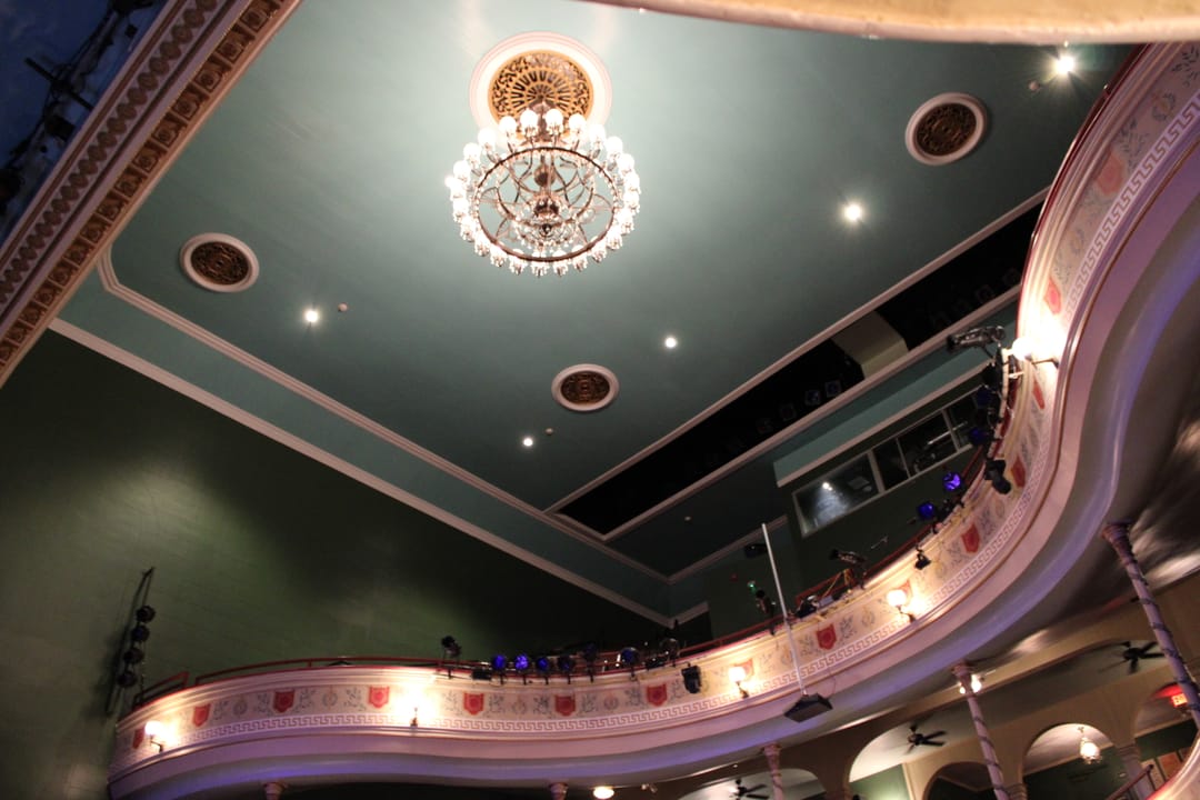 Looking up at the ceiling chandelier and curved double balconies inside Thalian Hall, March 2023.