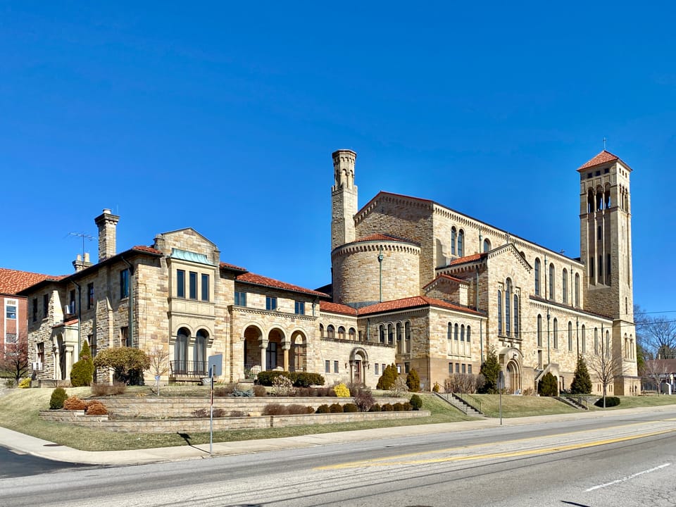 Built between 1929 and 1931, this Romanesque Revival-style church was designed by Joseph Steinkamp to house the congregation of St. William Catholic Church, founded in 1909.  Towering over the corner of West 8th Street and Sunset Avenue, the sandstone-clad church features a red tile roof, roman arch