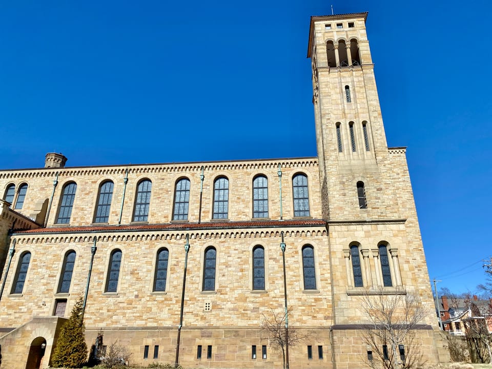 Built between 1929 and 1931, this Romanesque Revival-style church was designed by Joseph Steinkamp to house the congregation of St. William Catholic Church, founded in 1909.  Towering over the corner of West 8th Street and Sunset Avenue, the sandstone-clad church features a red tile roof, roman arch